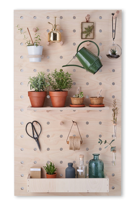 large wooden pegboard made from highest quality plywood with shelves and pegs with plants, watering can