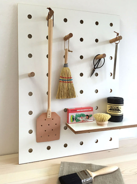 small white wood pegboard for storage on shelves and pegs