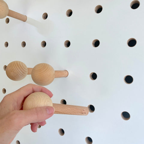 white wooden pegboard with solid beech round peg for hanging coats, bags etc on Kreisdesign pegboards