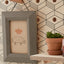 wooden pegboard shelf with plant pot and peg hook with hanging picture frame