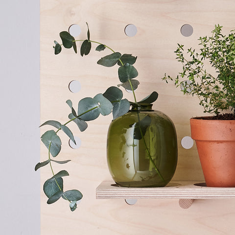 wooden pegboard shelf with vase and terracotta pot