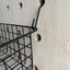 detail of hooks and wire basket hanging off wooden pegboard by kreisdesign