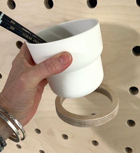 plywood hoop on pegboard with white pot