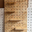 Pegboard with wooden pegs attached to a wall OSB with shelves
