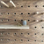 Walnut veneer birch plywood pegboard by kreisdesign with shelves and pegs that are fitted with pegs to slot into the pegboard holes