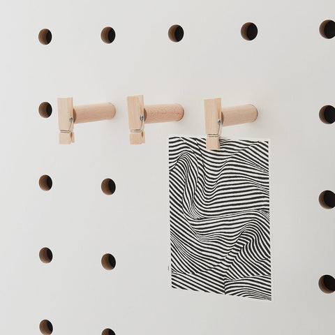 pegboard peg fitted with cloth peg holing postcard