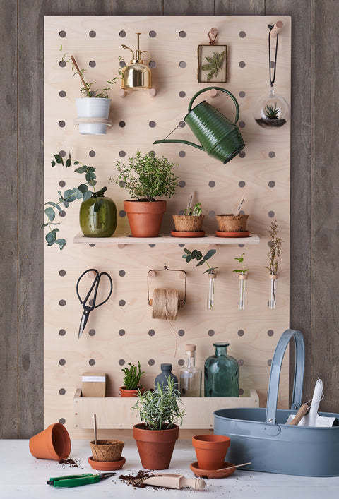 large wood pegboard with shelves wooden peg hooks in potting shed with plants and pot holder ring