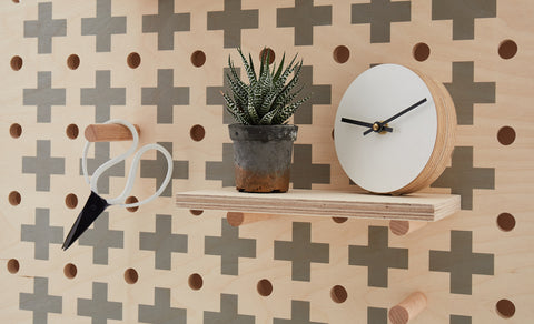 small wooden pegboard with cross pattern print with shelf and pegs