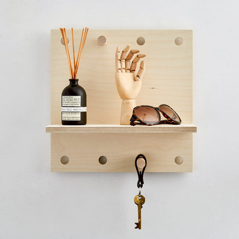small wooden wall shelf with wooden pegs