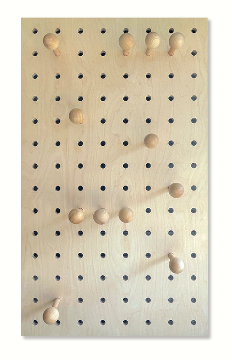 large wood pegboard with round pegs for hanging coats, bags